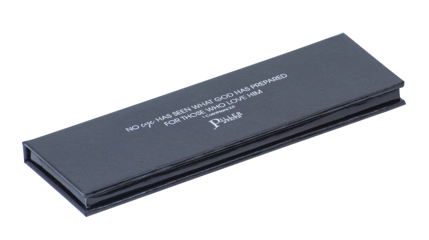 Image of closed black eyeshadow compact. Long and thin. Features scripture on cover: No eye has seen what God has prepared for those who love Him. 1 Corinthians 2:9. Piller of Faith logo below.